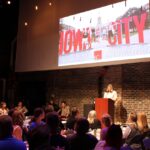 Iowa City Downtown District's executive director, Betsy Potter, takes the podium at the Englert Theatre for the 2024 State of the Downtown, June 5.