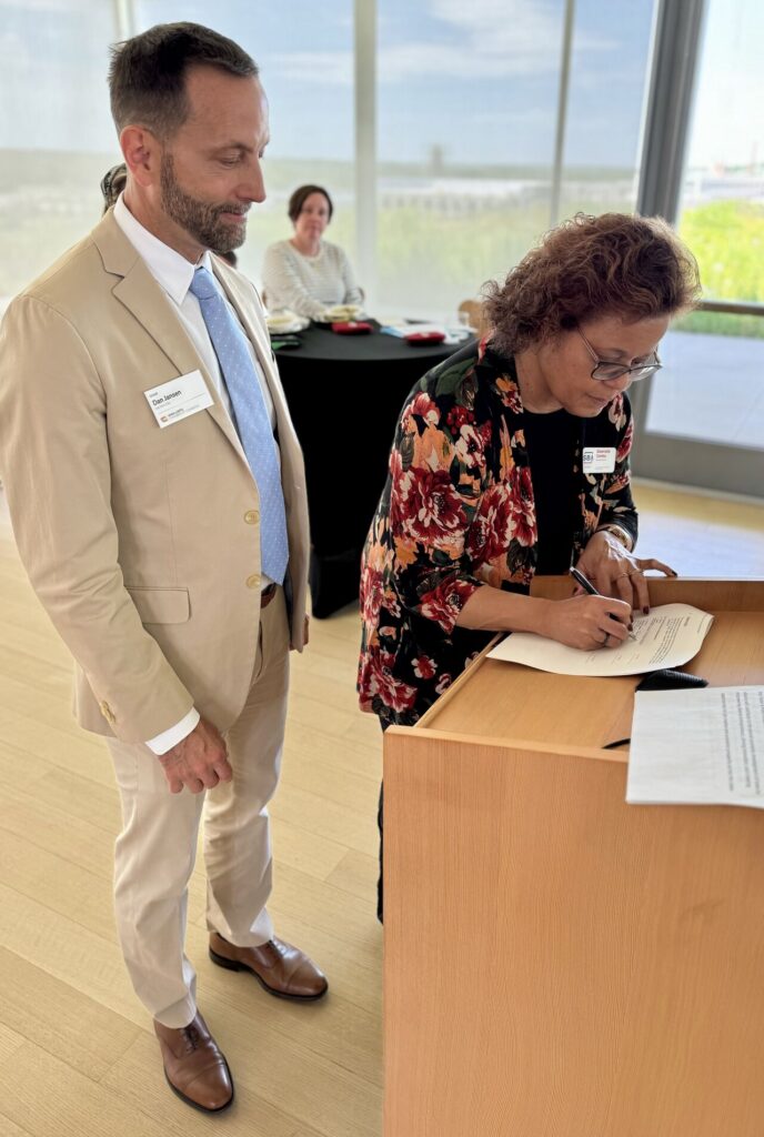 Dan Jansen, Iowa LGBTQ Chamber of Commerce chair, and Dawnelle Conley, SBA deputy district director, sign the strategic alliance memorandum on June 11 in Des Moines.