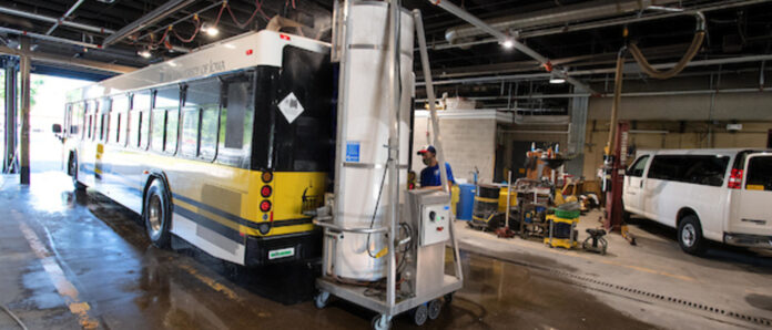Student employees clean and disinfect Cambus buses in the Bus barn.