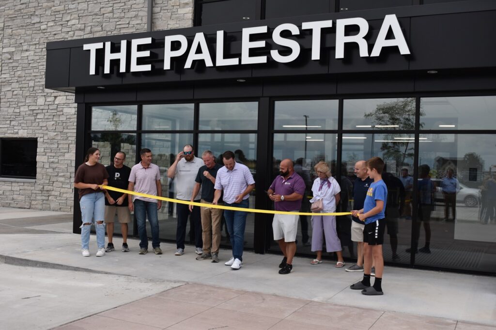 The Palestra co-owners Dave Lane and Brandon Prat prepare to cut the ribbon at the building's entrance July 9.