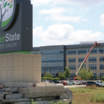 Crews with CR Signs work to install giant letters spelling “greenstate.org” atop GreenState Credit Union’s North Liberty headquarters on July 29, while the refreshed monument sign stands in front. The new signage marks the culmination of GreenState’s transition away from its former name, University of Iowa Community Credit Union, which was forced by a 2018 state law prohibiting credit unions from using the name of any Iowa public university. PHOTO ADAM MOORE