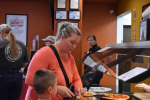 Diner Janaya Brown helps her son, Keaton, to a slice of pizza Aug. 19.