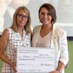 Candi Karsjens, director for the North Iowa Area Community College JPEC, presents Repaint Studios owner Billie Kay Ingalls Asmus with a check.