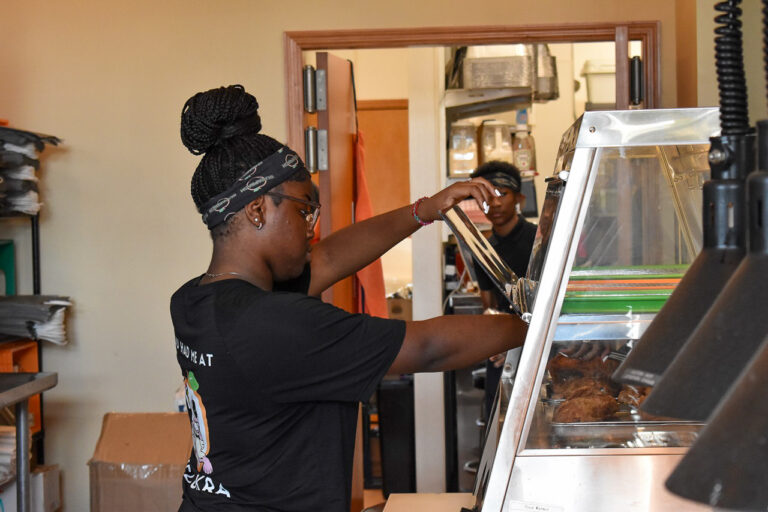 Savannah Dixon, 17, reaches for some fried chicken with a pair of tongs. Ms. Dixon has worked at Sugapeach Chicken & Fish Fry for two years. CREDIT ANNIE SMITH BARKALOW