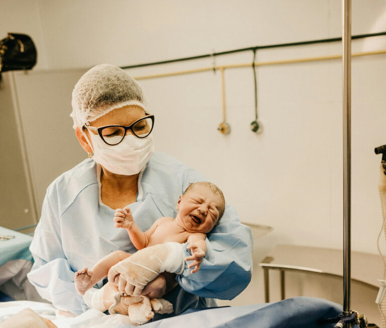 A doctor holds a newborn baby.