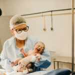 A doctor holds a newborn baby.