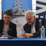 St. Ambrose president Amy Novak and Mount Mercy president Todd Olson sign a "strategic combination" agreement on Thursday, Aug. 1. CREDIT ANNIE SMITH BARKALOW