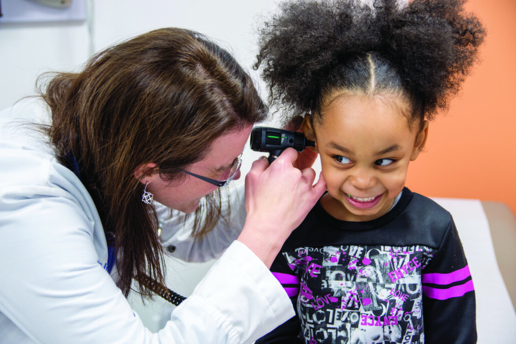 A medical professional examines a young patient at the Eastern Iowa Health Center. CREDIT EIHC