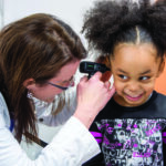 A medical professional examines a young patient at the Eastern Iowa Health Center. CREDIT EIHC