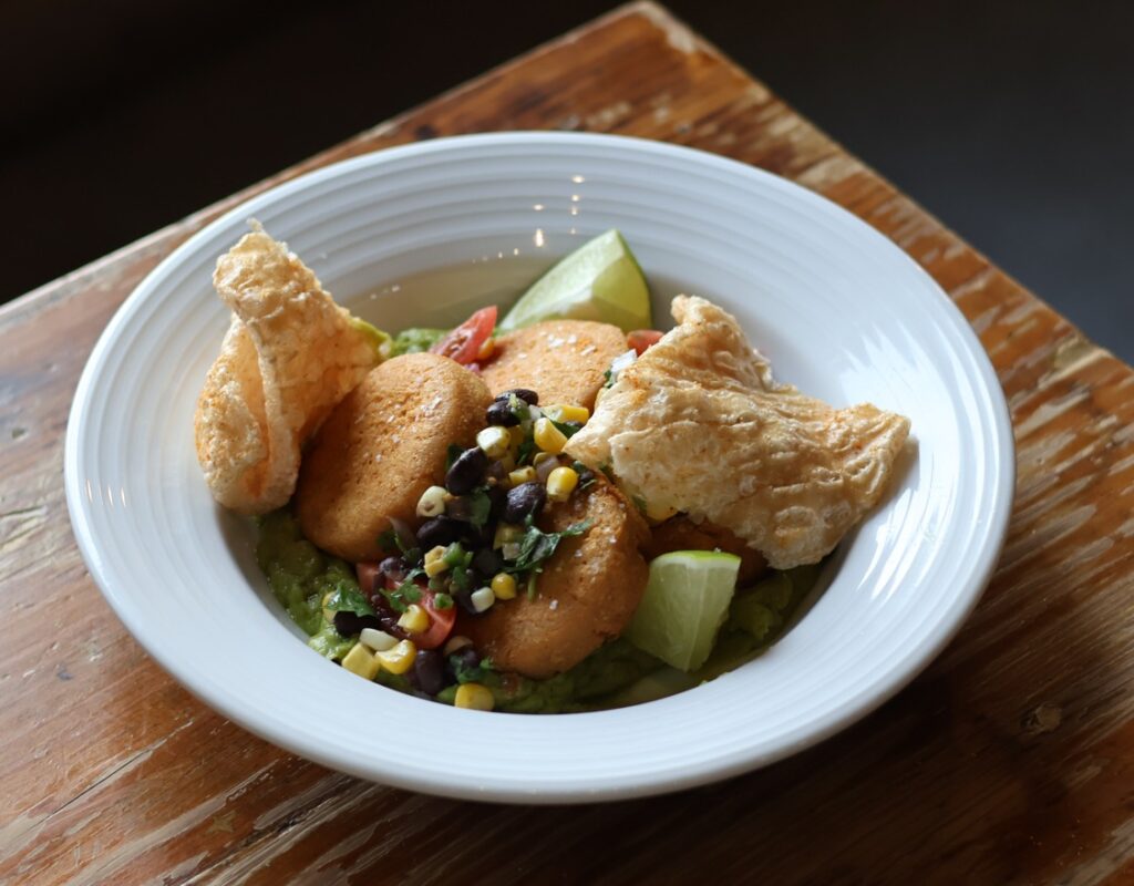 Wilson Orchard & Farm's Iowa City summer menu features the Heirloom Masa Arepas. Made with creamy Queso Oaxaca, fresh sweet corn, and a savory black bean criolla, and topped with crispy pork chicharrones. Wilson's Iowa City location will host the first dinner in a series of farm-to-table events put on by The Iowa Tourism Office and Choose Iowa have partnered with the Iowa Restaurant Association.
