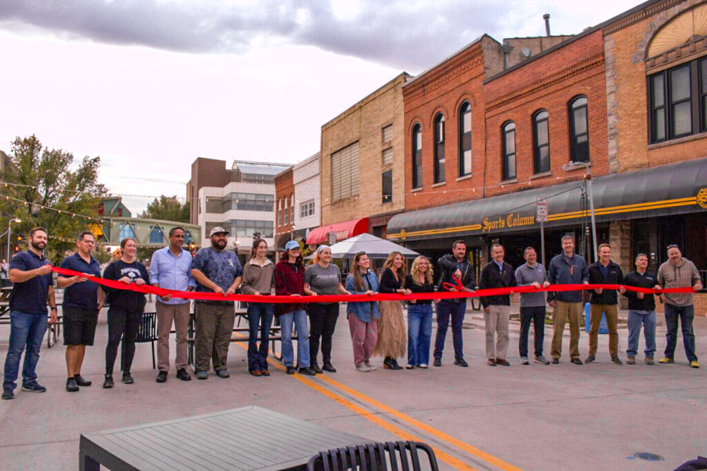 Dubuque Street business owners cut a ceremonial ribbon ahead of the Back to Dubuque Street celebration on Oct. 24, 2024, in Iowa City. CREDIT PARKER JONES