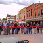 Dubuque Street business owners cut a ceremonial ribbon ahead of the Back to Dubuque Street celebration on Oct. 24, 2024, in Iowa City. CREDIT PARKER JONES