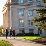 Students walk past Jessup Hall on the Pentacrest on a fall afternoon.