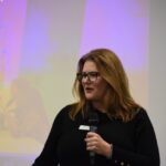 Christine Landa, president of Junior Achievement of Eastern Iowa, addresses a room of local business and education leaders.