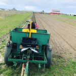 A worker with Grimm Family Farm plants potatoes in April 2020. The business is the only supplier of dry beans in Iowa and is one of several businesses to receive a USDA RFI grant.