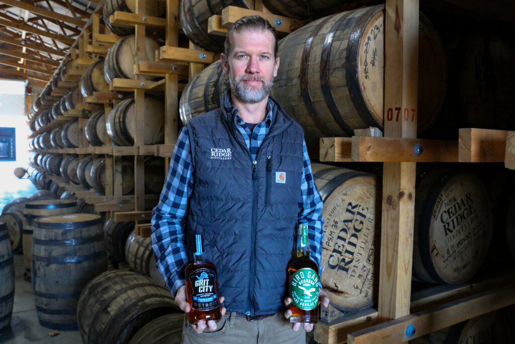 Jamie Siefken, president and general manager of Cedar Ridge Distillery in Swisher, holds bottles of Grit City and Bird Gang bourbon in one of the distillery's barrel sheds. CREDIT RICHARD PRATT