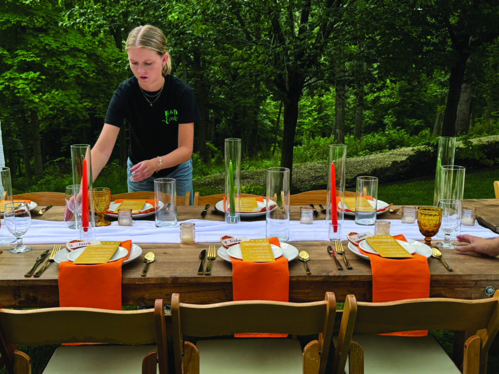 A student in the University of Iowa's event management program sets a table at a private event.