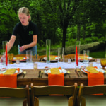 A student in the University of Iowa's event management program sets a table at a private event.
