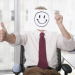 iStock Businessman holding picture of happy face toxic positivity