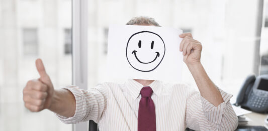 iStock Businessman holding picture of happy face toxic positivity