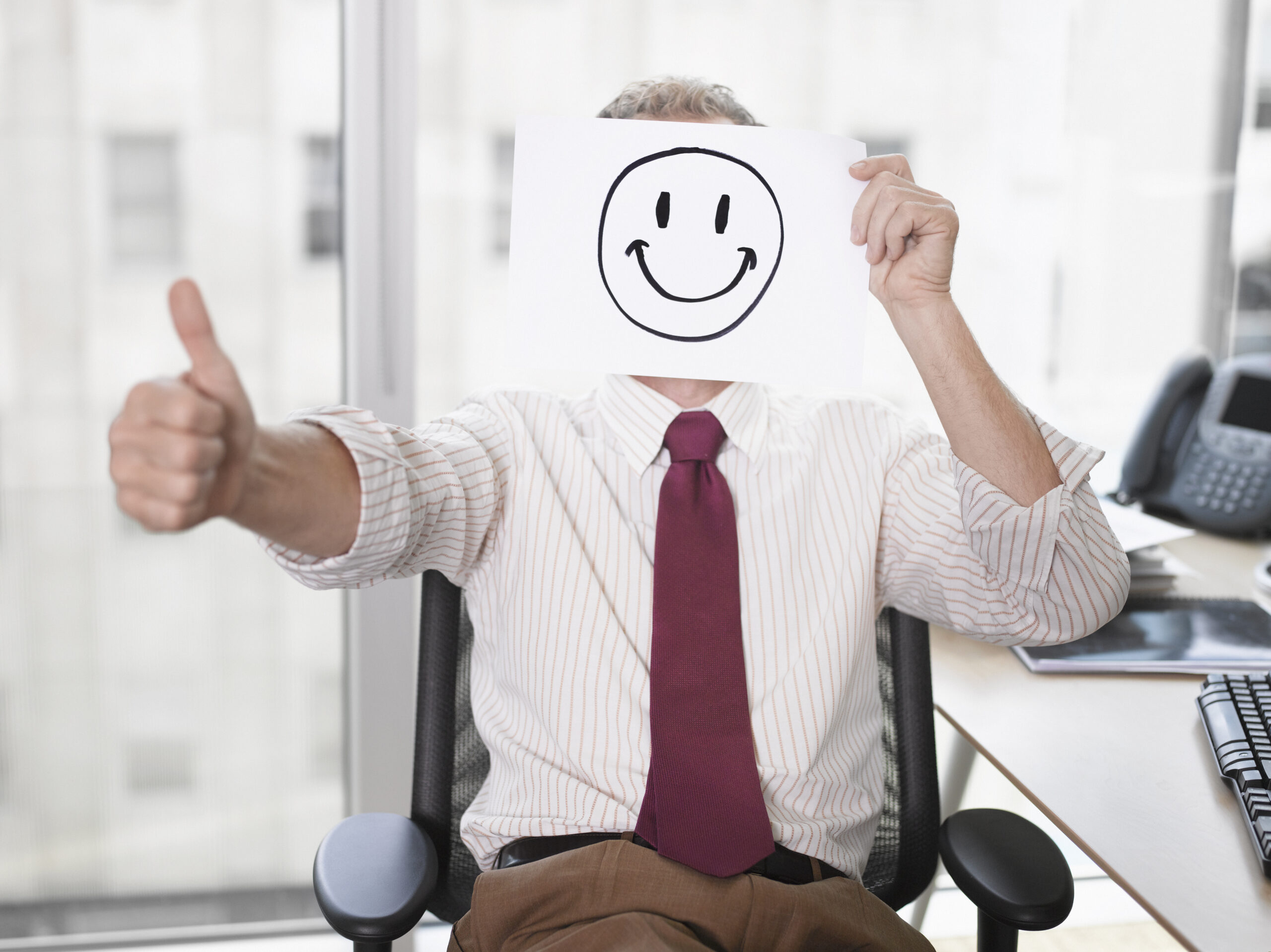 iStock Businessman holding picture of happy face toxic positivity
