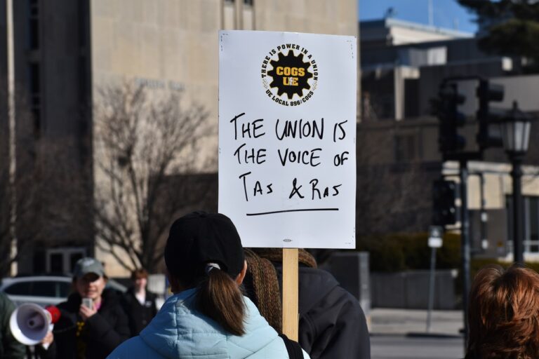 A protestor holds a sign that reads "The union is the voice of TAs & RAs" at the COGS' protest rally Jan. 29 at the Pentacrest on the Iowa City campus.