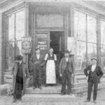 A historical photo shows George Buffon – wearing a white apron – standing in front of the saloon he owned at 401 E Market St, Iowa City, in 1899. The identities of the others in this photo are unknown. CREDIT JOHN’S GROCERY ARCHIVES
