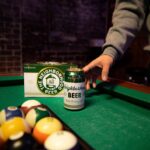 A Big Grove Brewery Neighborhood beer can sits on a pool table.