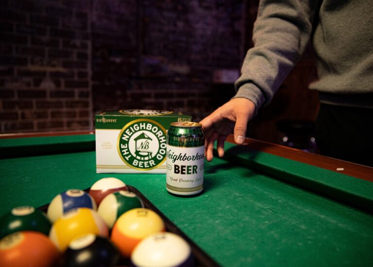 A Big Grove Brewery Neighborhood beer can sits on a pool table.