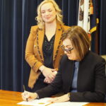 Gov. Kim Reynolds, right, signed an executive order Feb. 10, 2025 establishing the state DOGE task force, joined by Emily Schmitt, general counsel for Sukup Manufacturing Co. who she chose to lead the initiative. (Photo by Robin Opsahl/Iowa Capital Dispatch)