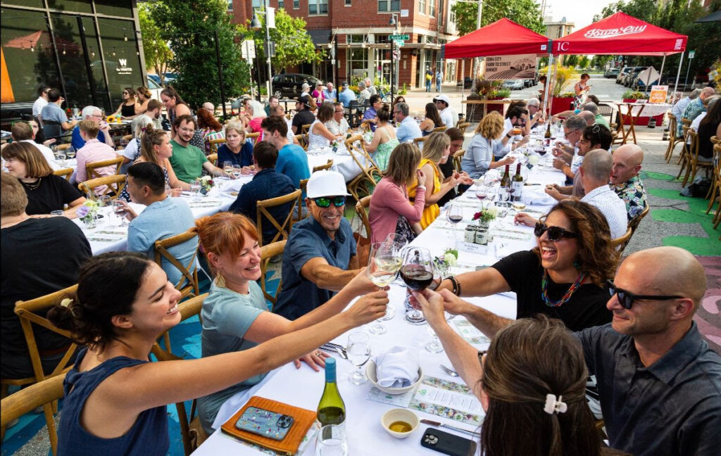 Diners from a past Farm to Street Dinner raise their glasses in a toast.