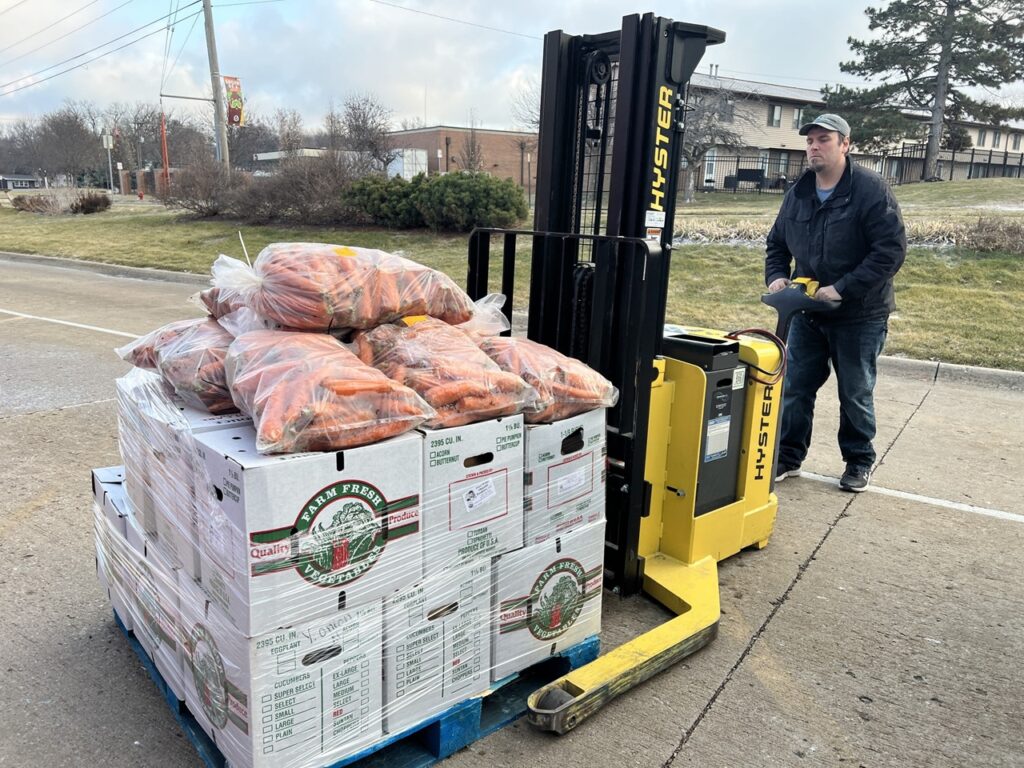 A Field to Family volunteer readies a pallet of fresh produce for delivery to local schools in December. The food nonprofit says cuts to the LFS and LFPA programs will hurt its ability to provide access to local food and education for those who need it most.