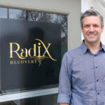 Radix Recovery executive director Jacob Christenson is shown outside the clinic’s outpatient facility at the former Higley Mansion in southeast Cedar Rapids. CREDIT RICHARD PRATT