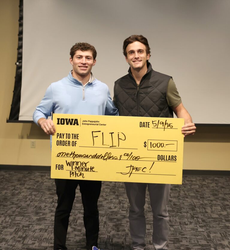 University of Iowa undergraduates Patrick Igo and Landon Stoll with FLIP hold a check for $1,000 at UI JPEC's Undergraduate Startup Incubator End of Semester Pitch Competition May 9.