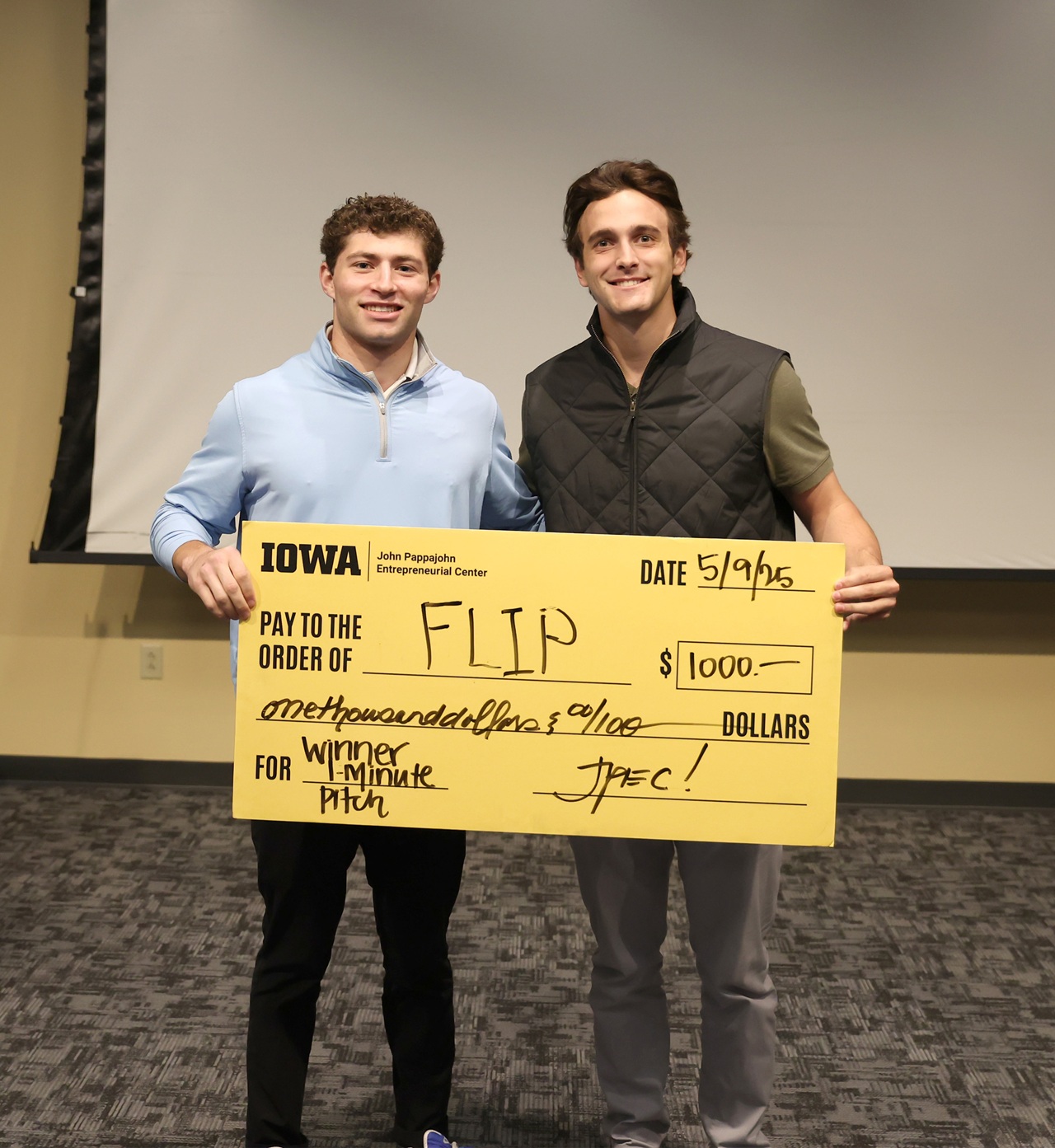 (Photo by Darren Miller) University of Iowa undergraduates Patrick Igo and Landon Stoll with FLIP hold a check for $1,000 at UI JPEC's Undergraduate Startup Incubator End of Semester Pitch Competition May 9.