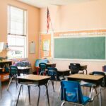 An empty classroom with an American flag hanging in the corner.