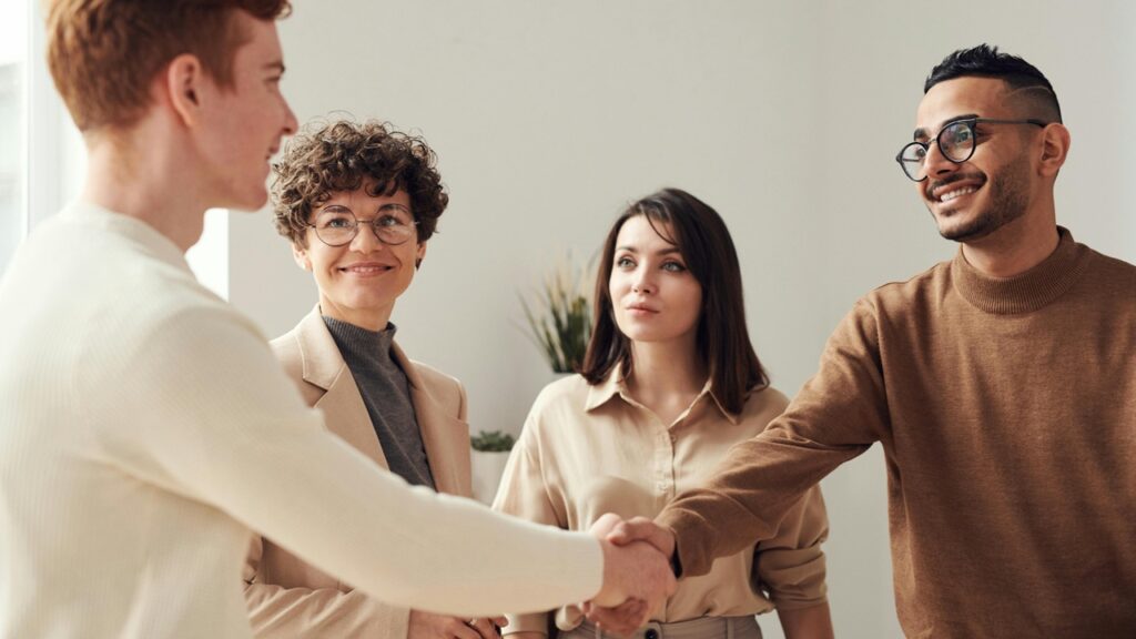 Two young professionals shake hands.