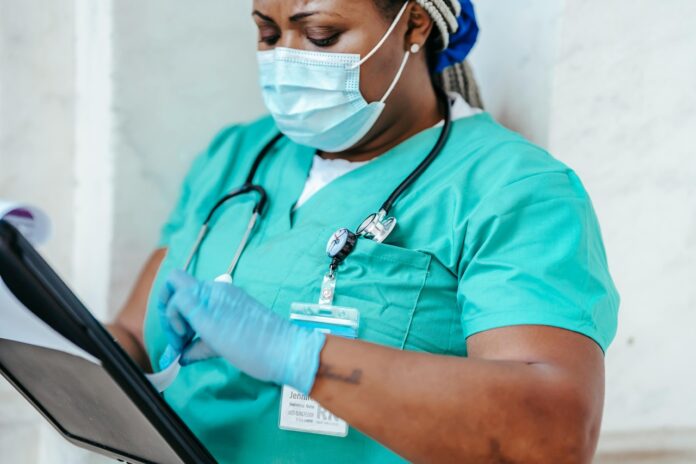 pexels-laura-james-6098054 A nurse looks over her notes.