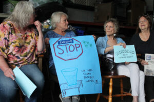 Johnson County manufactured housing park residents Constance Blakeslee, Linda Hickson, Judy McKillip, Linda Parrish hold signs during the press conference June 18.