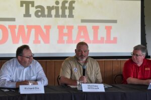 Panelist Richard Dix with Kinze Manufacturing (left) listens to Matthew Willimack discuss the impact of tariffs on farmers.