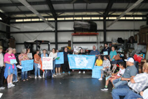 Advocates and residents of mobile home parks in Johnson County hold signs following the press conference June 18.