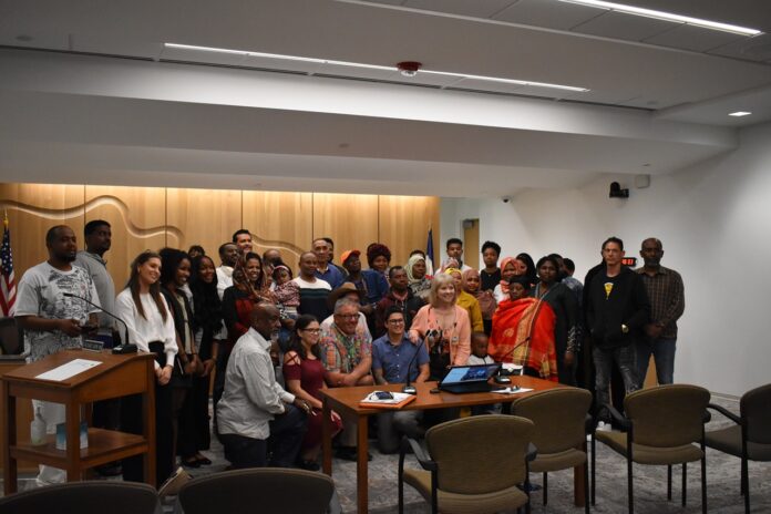JoCo Board of Supervisors Audience members and presenters of the proposed immigrant welcome center pose with the Johnson County Board of Supervisors June 4, 2025.