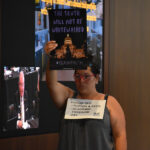 A protestor holds a sign depicting the Iowa Capitol accompanied by the words "The truth will not be whitewashed" at the Iowa Board of Regents meeting Wednesday, June 11.