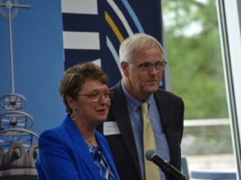St. Ambrose President Amy Novak and Mount Mercy President Todd Olson celebrate the first phase of their universities' merger with a symbolic signing Friday, June 27.