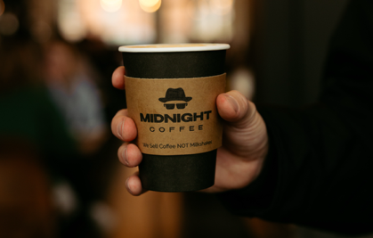 MidnightCoffee Midnight Coffee's logo is prominently displayed on a disposable coffee cup.