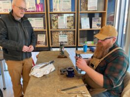 IC Repair volunteer Chris Anderson sharpens a knife for an attendee April 4.