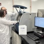 IDT quality control specialists Austin Kraff (background) and Jacob Draghicchio (foreground) load QC samples onto a Capillary Electrophoresis instrument to assess product purity.