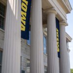 A student studies while leaning against a column of the old capitol.
