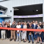 Iowa City Bike Library staff, volunteers, board members and participants cut the ribbon on the new youth hub at the organization's Bikes Create Community campaign Sept. 4.