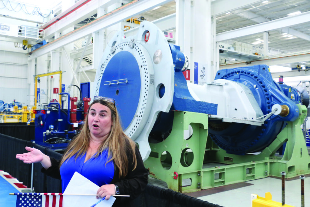 A Nordex USA employee describes one of the company’s wind turbine drivetrain assemblies during a tour of the company’s reopened plant in West Branch July 1, 2025. CREDIT RICHARD PRATT